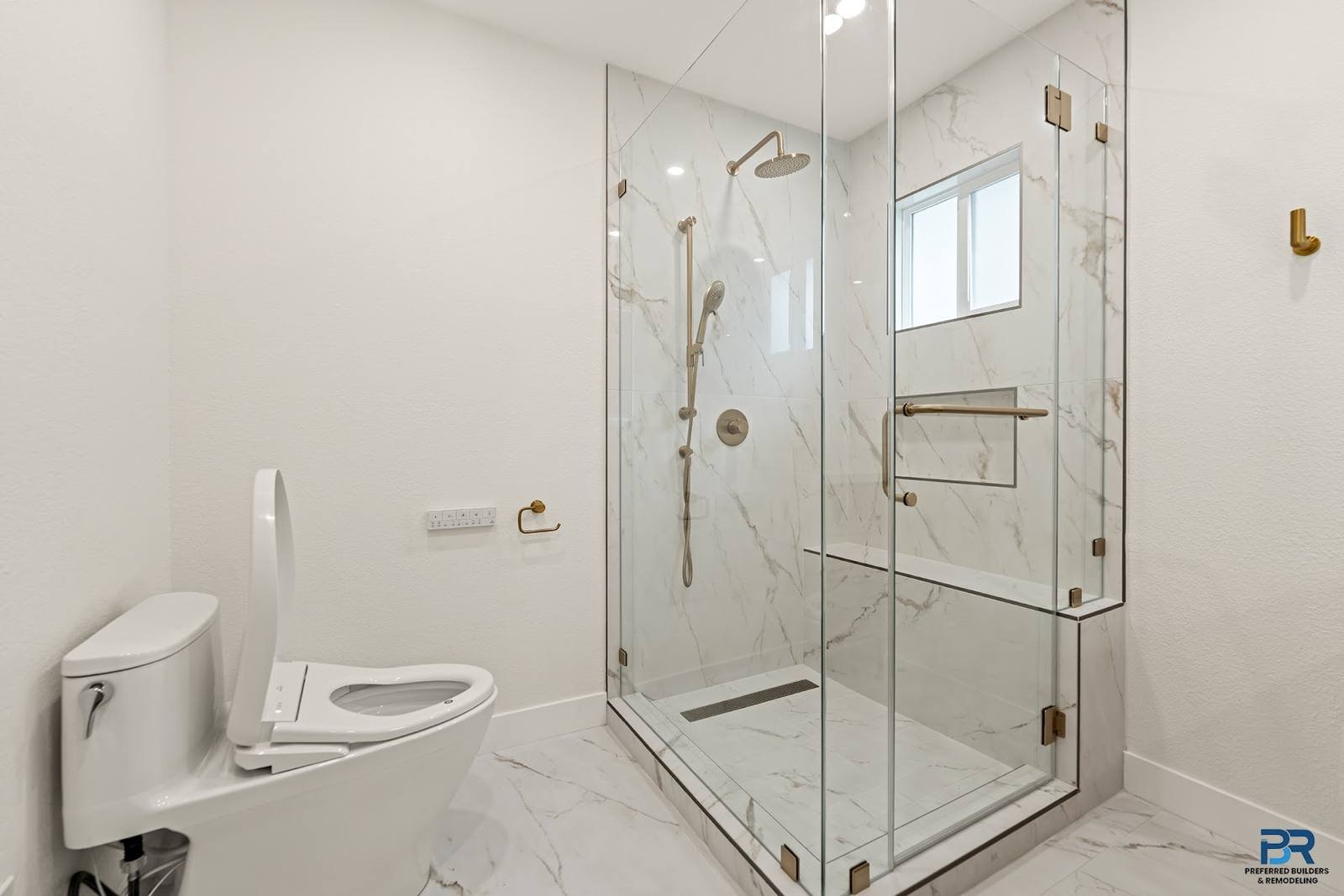 Glass shower with marble-look tile in a remodeled San Jose bathroom