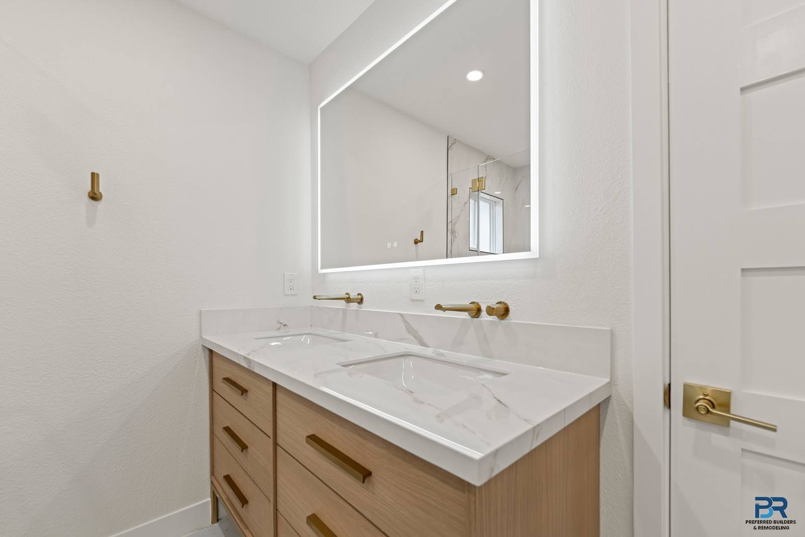 Wood vanity with a lighted mirror in a remodeled San Jose bathroom