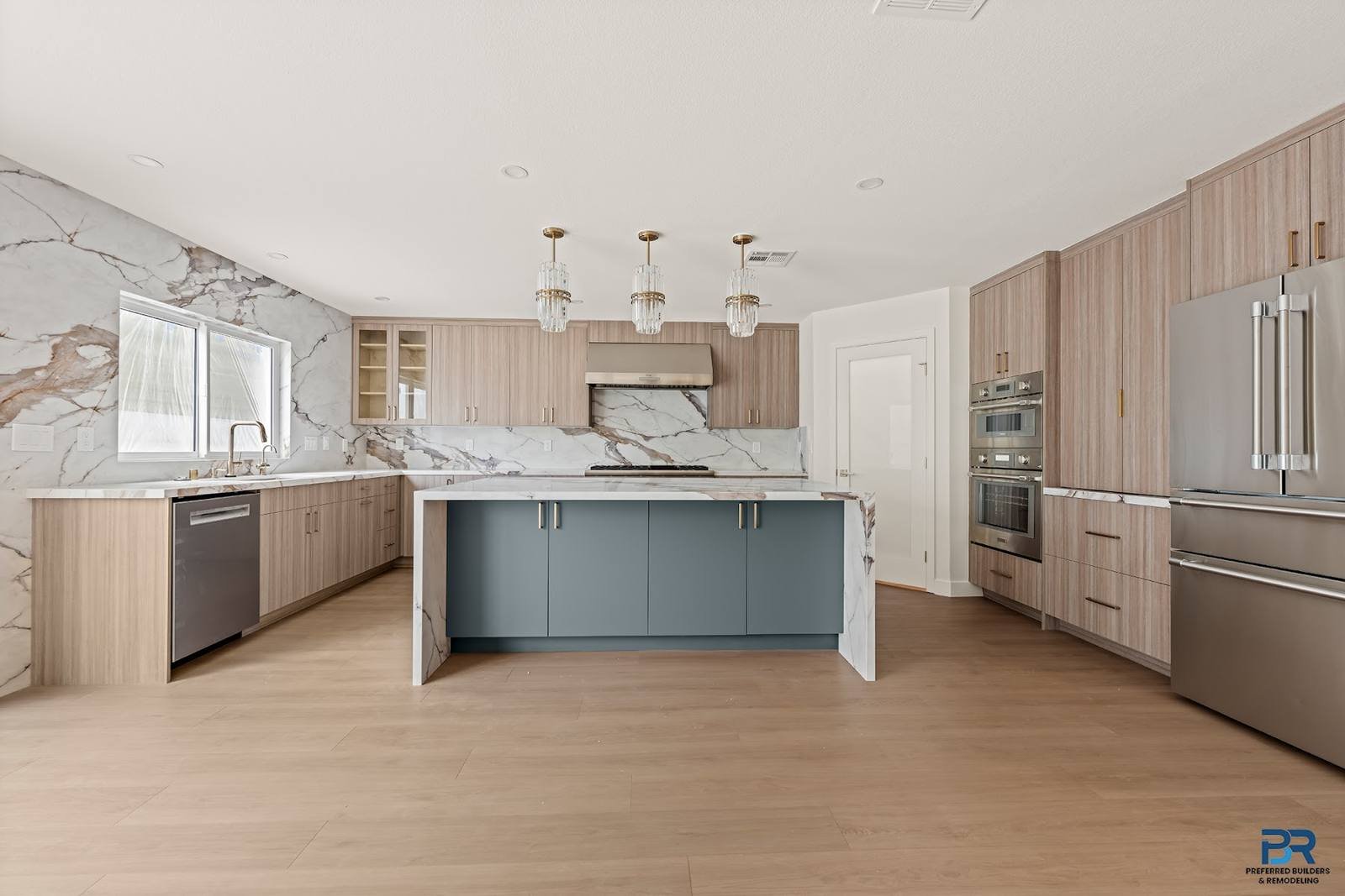 Remodeled kitchen with wood cabinets, marble backsplash and a blue island in San Jose