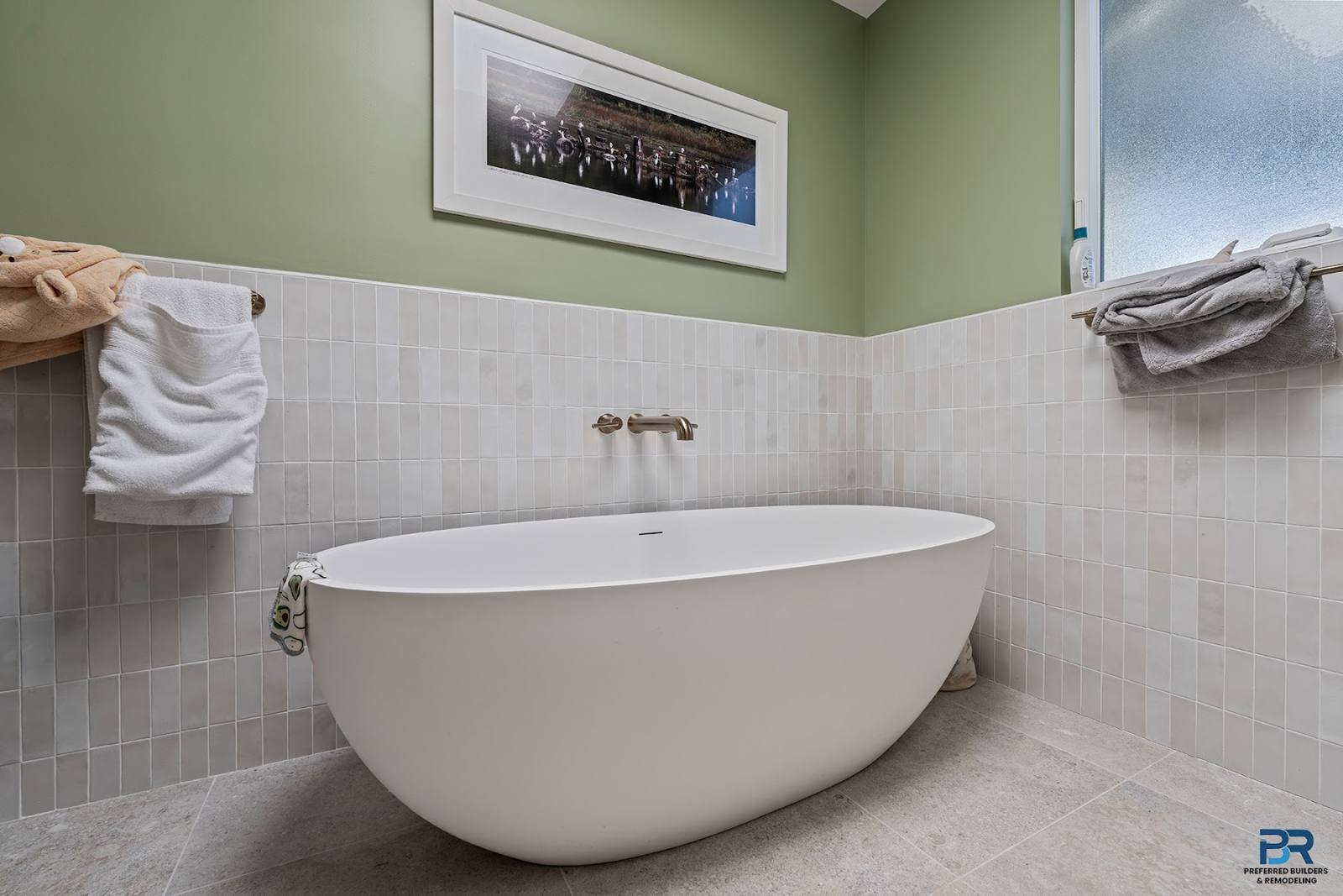 Bathroom with a freestanding tub, sage green walls and gray tile in a San Carlos whole-house remodel