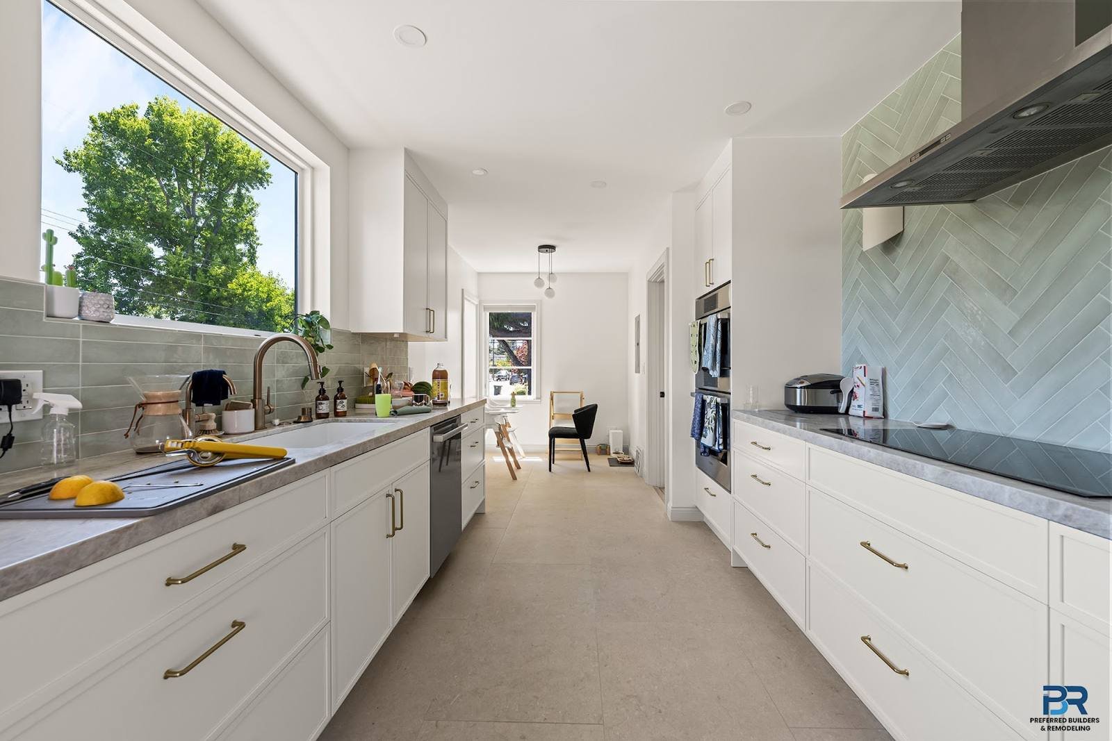 Galley kitchen with white cabinets and a window over the counter in a San Carlos whole-house remodel