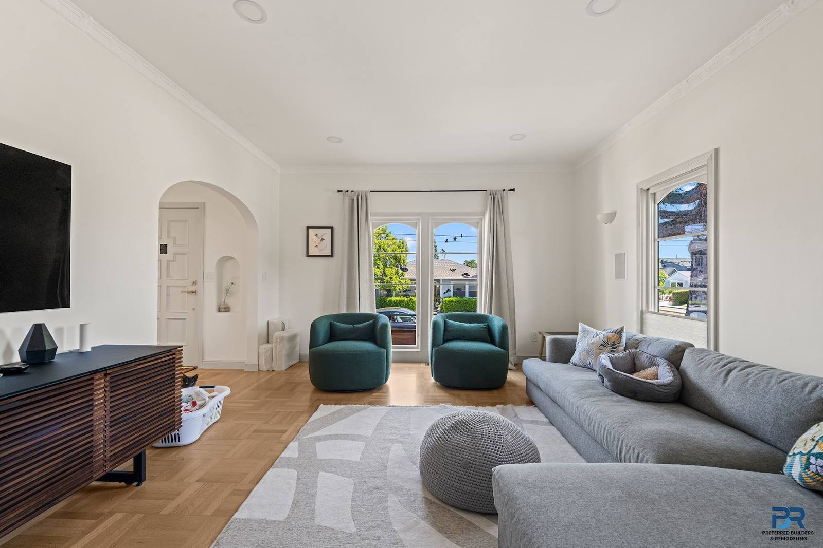 Living room with new wood flooring and an arched doorway in a San Carlos whole-house remodel