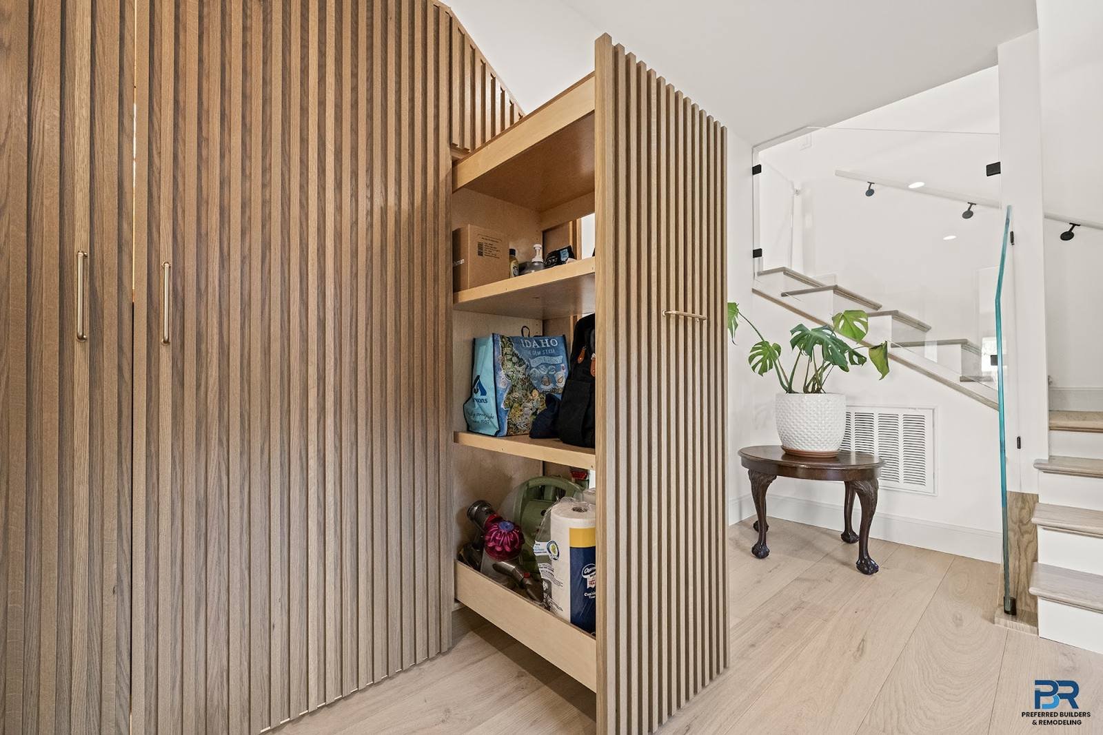 Lower level with a slatted wood storage wall and light oak flooring in a San Carlos whole-house remodel