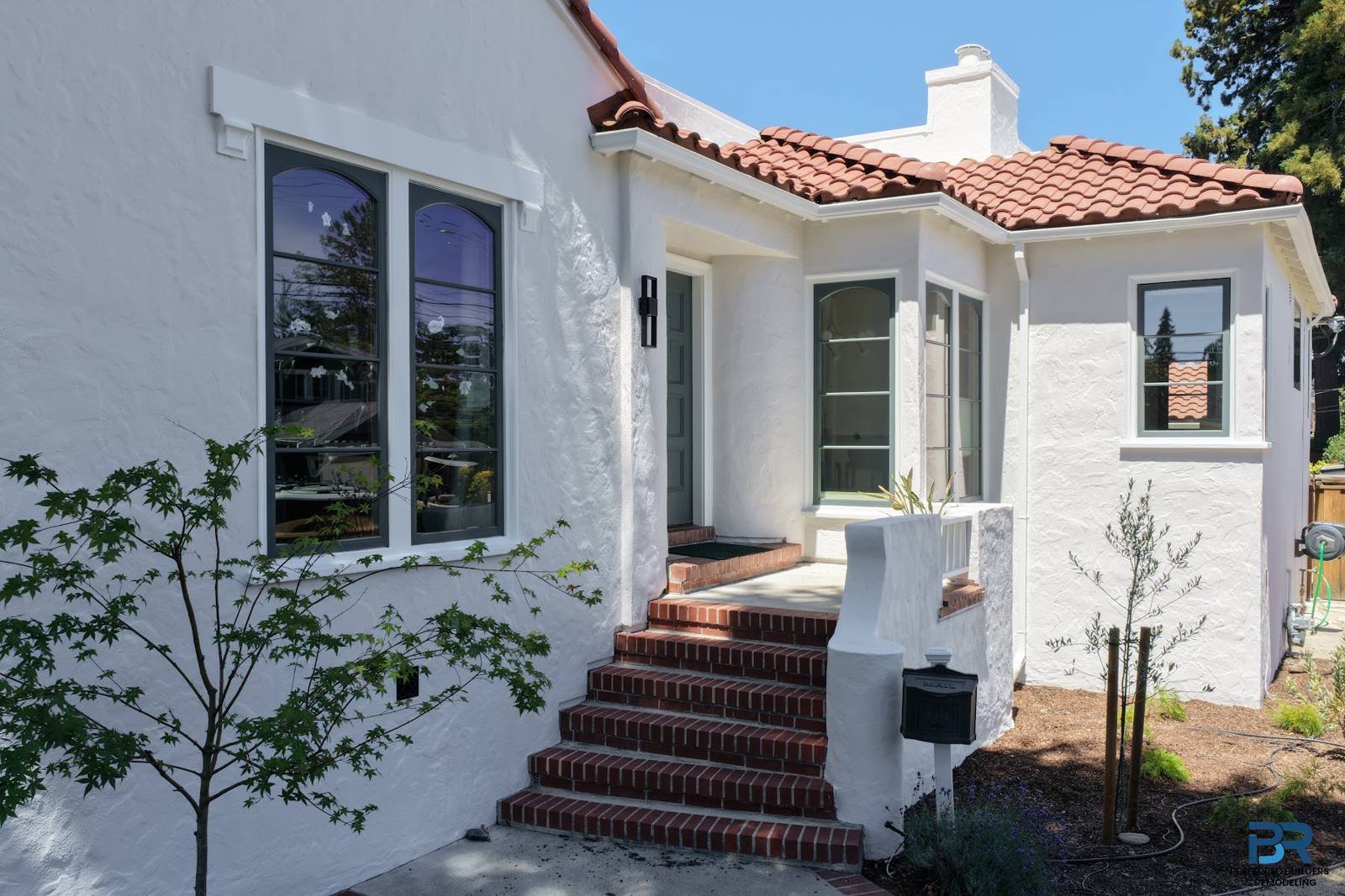 White stucco home with a red tile roof and brick front steps in a San Carlos whole-house remodel